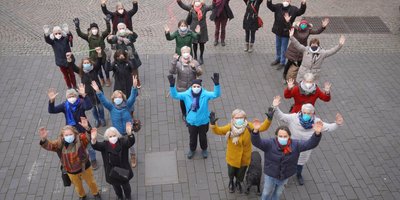 Das Foto zeigt Ehrenamtliche des AKHD Bonn, die eine "10" bilden.