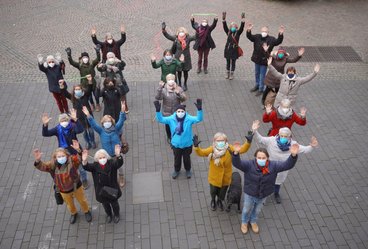 Das Foto zeigt Ehrenamtliche des AKHD Bonn, die eine "10" bilden.