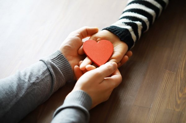 Hands of a woman holding and offering a heart shape. Love, health concept. Selective focus.